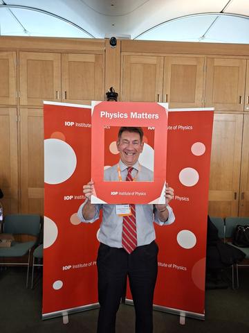 Philip Burrows smiling with Physics Matters